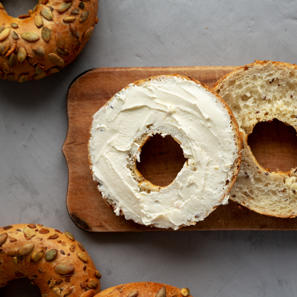 Homemade Whole Grain Bagel with Cream Cheese on a rustic wooden